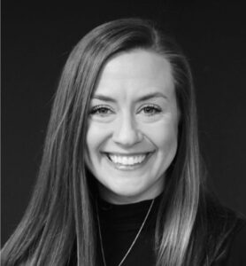Professional black and white headshot of a woman with long hair with black shirt.