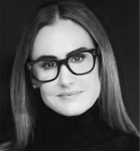 Professional black and white headshot of a woman with long hair and glasses.