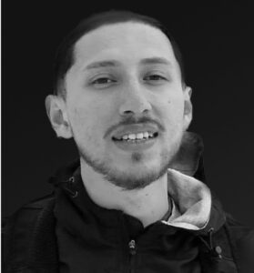 Louis Mendez Black and white headshot of a man with short hair and jacket.
