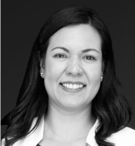 Professional black and white headshot of a woman with long hair in white collar shirt.